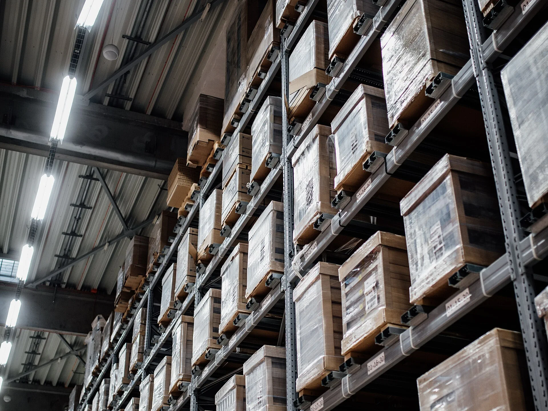 Warehouse racking stacked with labeled, palletized inventory boxes